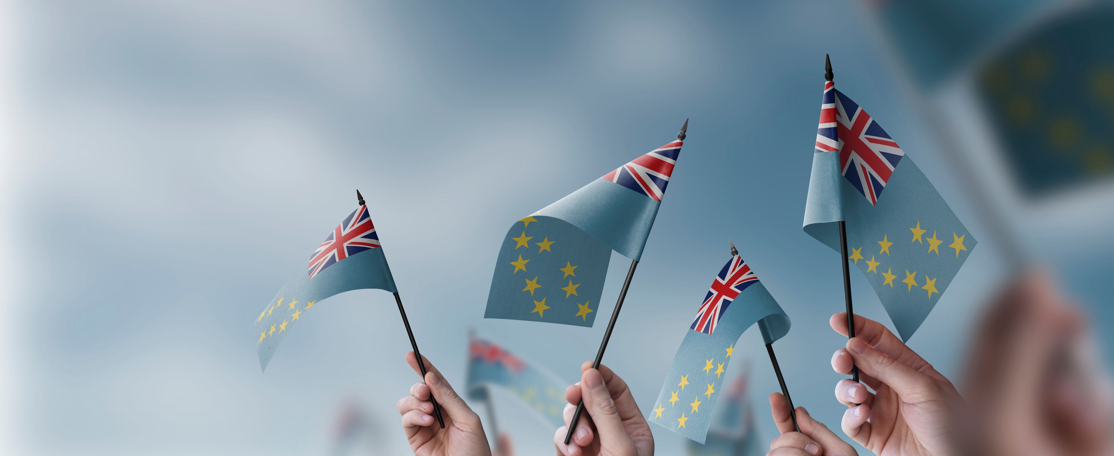 Hands holding flags with the Union Jack and the European Union flag.