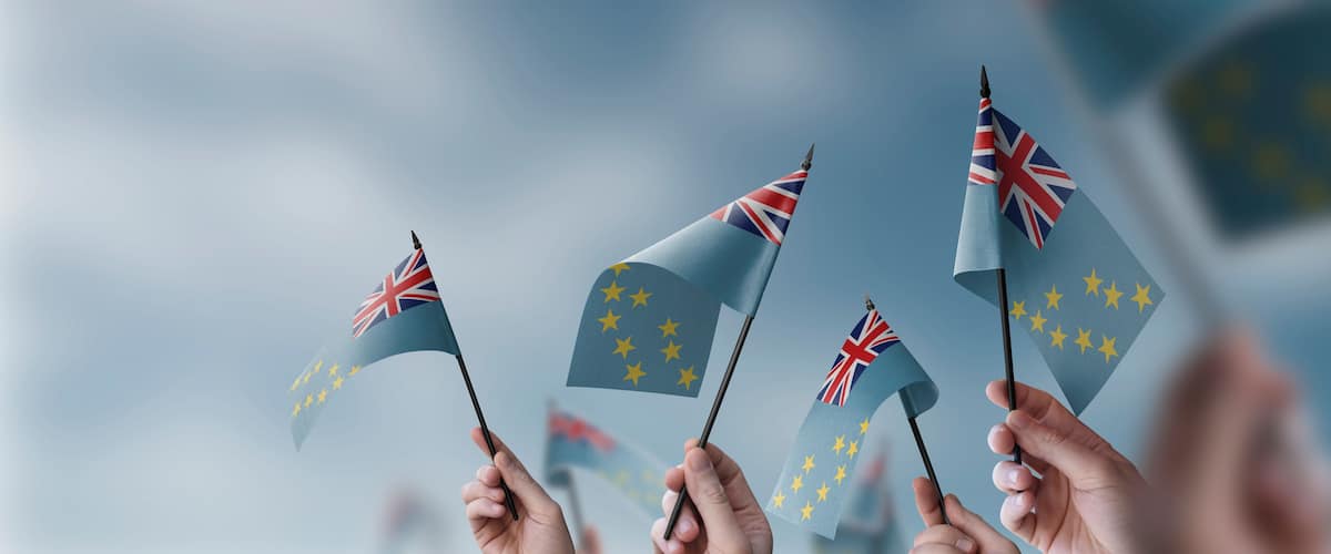Hands holding flags with the Union Jack and the European Union flag.