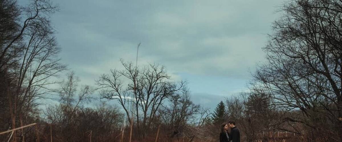 A person standing by a river in a wooded area.