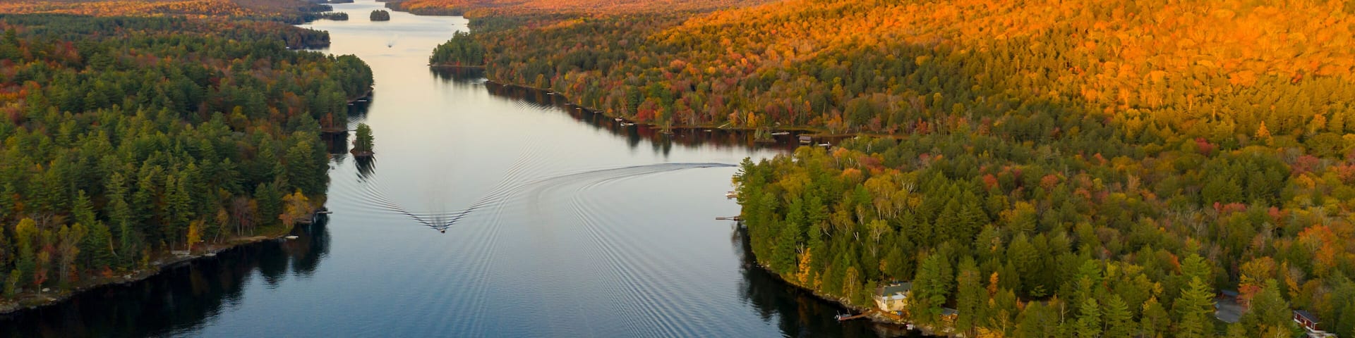 A river winding through a forested valley with hills in the background.
