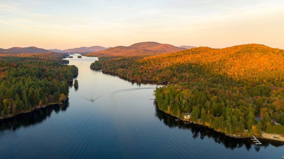A river winding through a forested valley with hills in the background.