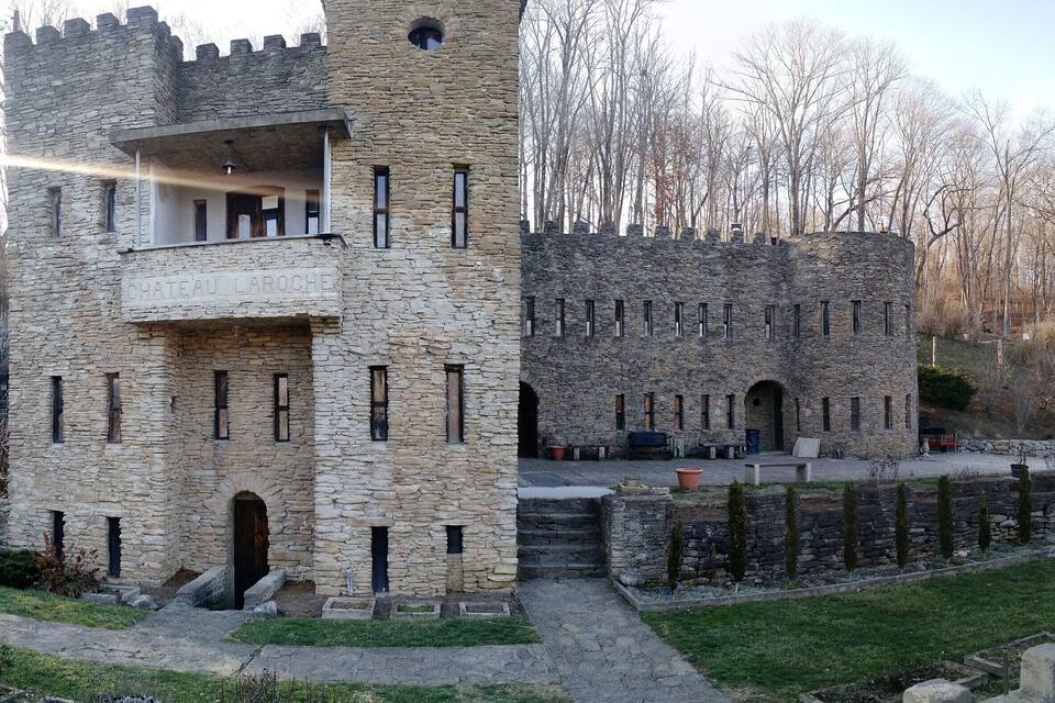 Château Laroche, a stone castle with a balcony and arched windows.