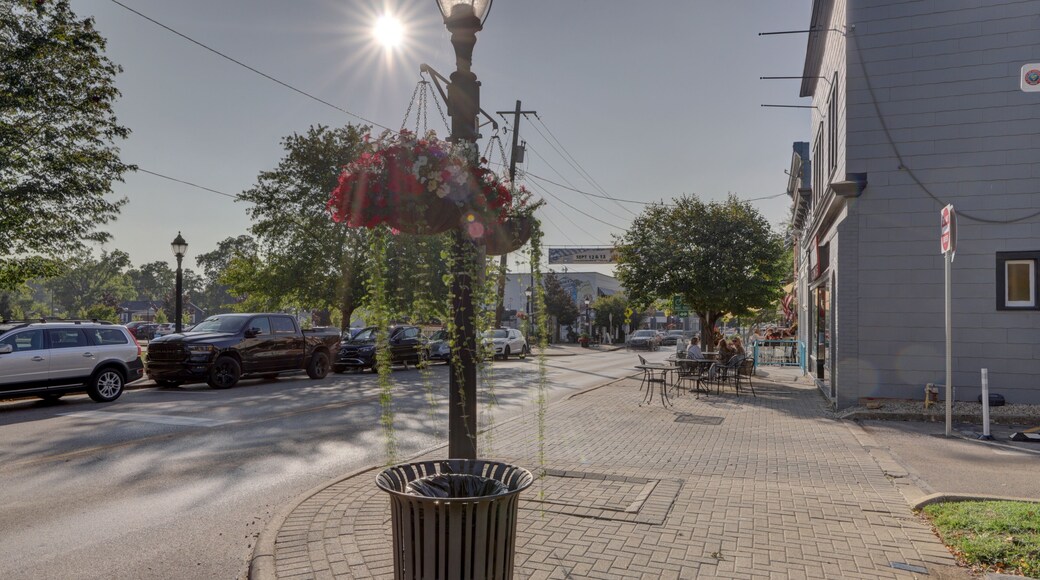 View of the sun casts a warm glow on the brick sidewalk, highlighting the flower basket hanging from an antique lamp post, Loveland, Ohio, United States.
