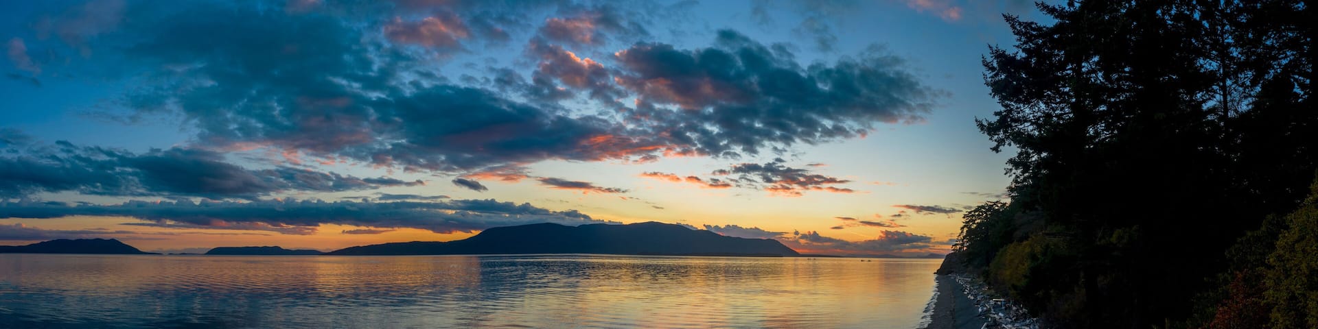 Sunset Over Orcas Island in the Salish Sea and the San Juan Island Archipelago. Beautiful and dramatic sunset with colorful clouds and a calm sea in the Pacific Northwest.