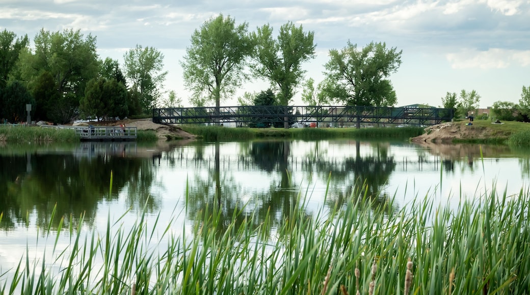 A river with a bridge, trees, and a boat.