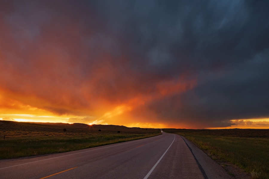 Sunset over highway 59 north of gillette, wyoming with storm clouds