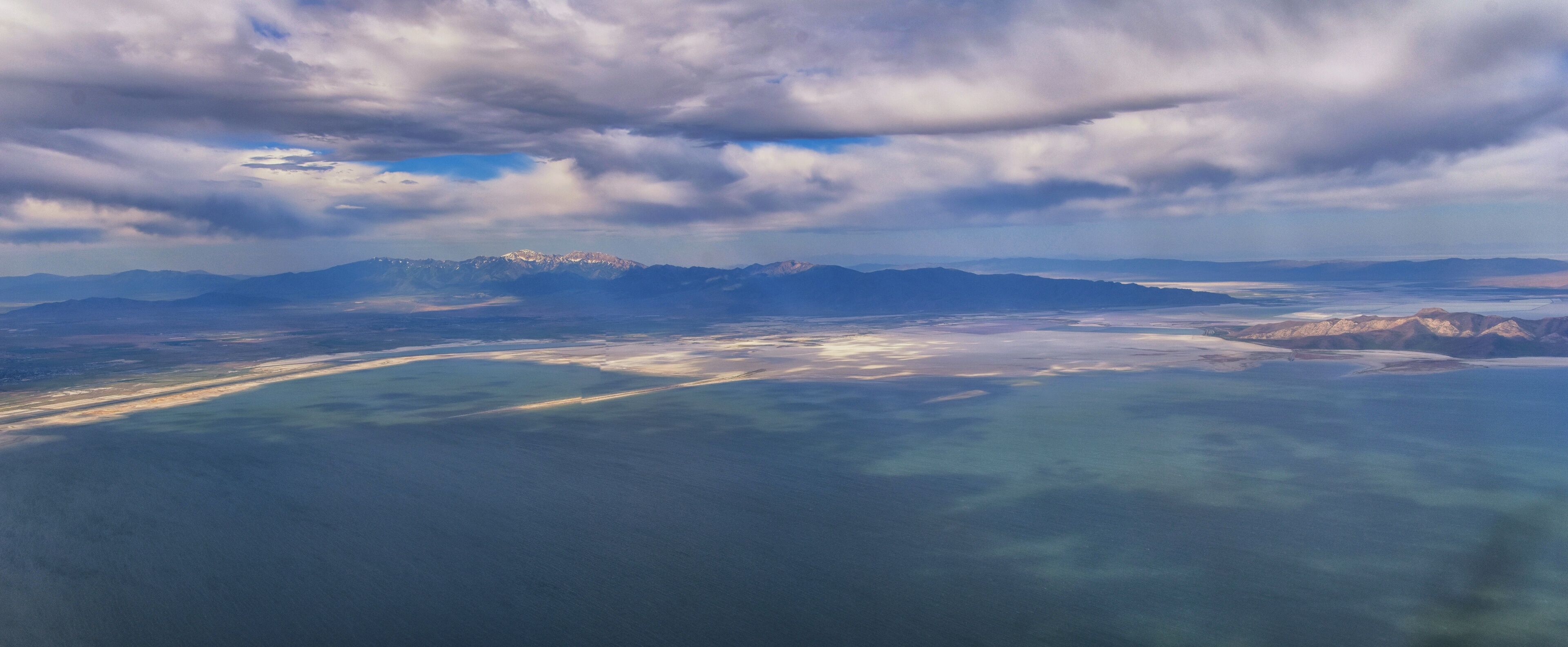 Great Salt Lake Utah Aerial view from airplane looking toward Oquirrh Mountains and Antelope Island, Tooele, Magna, with sweeping cloudscape. United States.