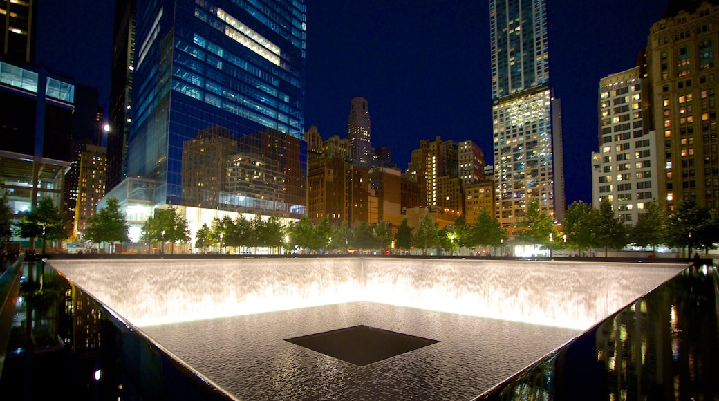 The National September 11 Memorial showing a fountain, night scenes and a city