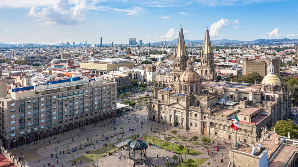 A cityscape with a prominent cathedral, a large square, and surrounding buildings.