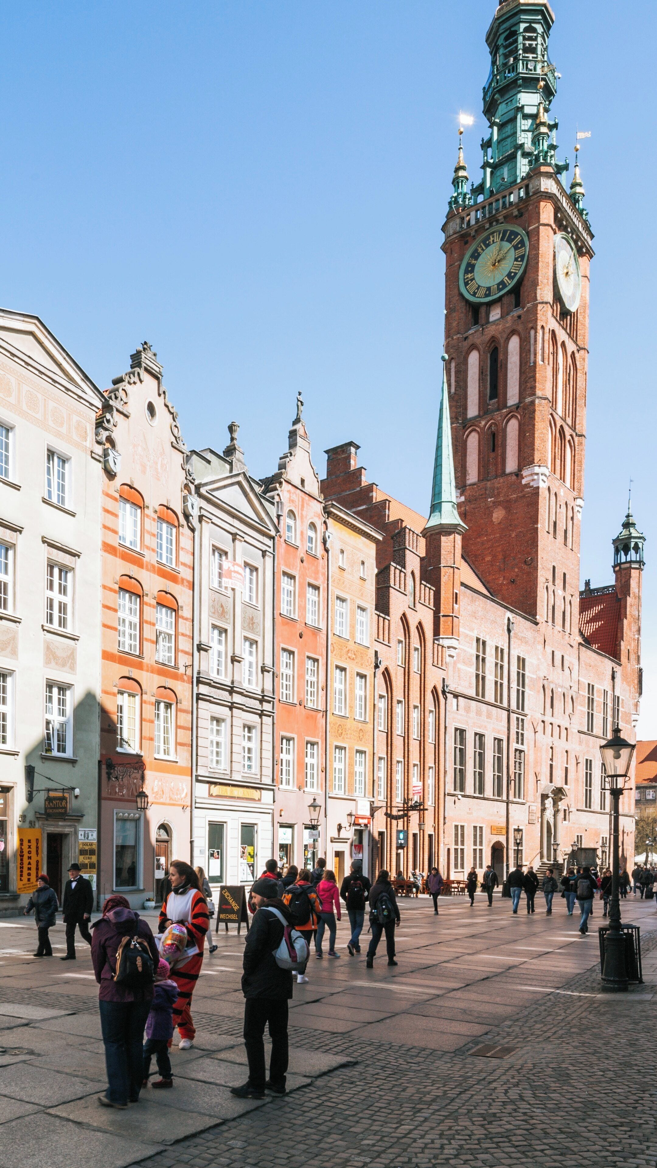 Historic Gdansk Main Town Hall stands tall among vibrant architecture in Gdansk City Center during a sunny day