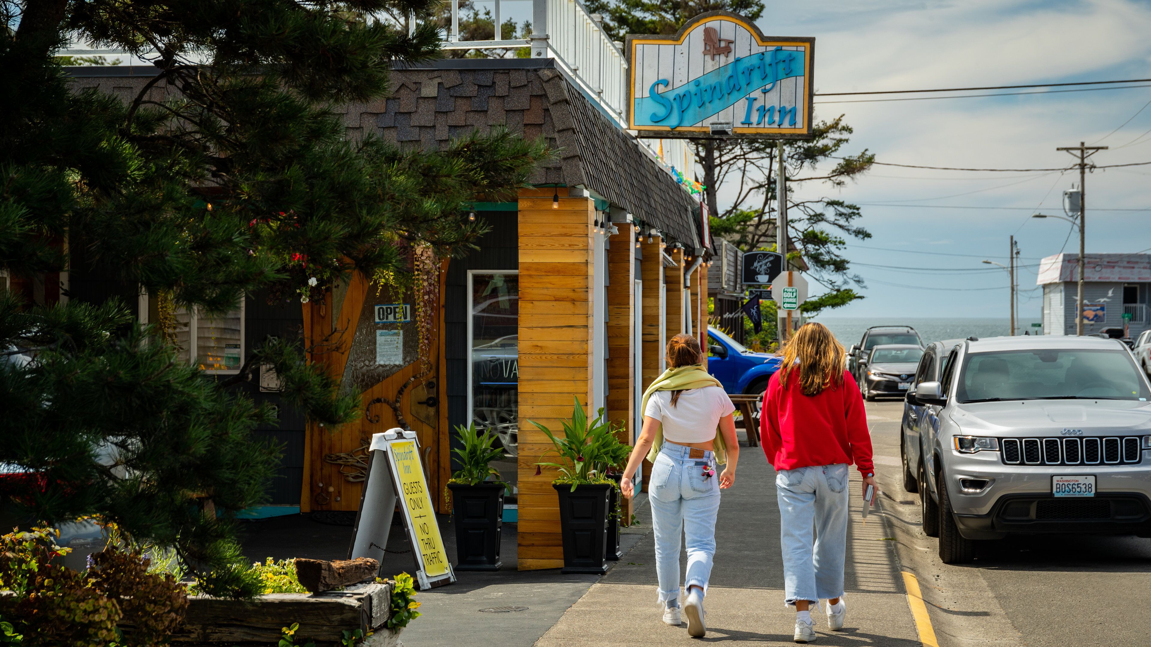 A building with a sign reading "Spindrift Inn" and a wooden door with a sign that says "OPEN".