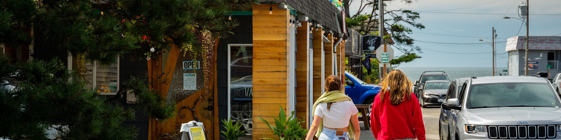 A building with a sign reading "Spindrift Inn" and a wooden door with a sign that says "OPEN".