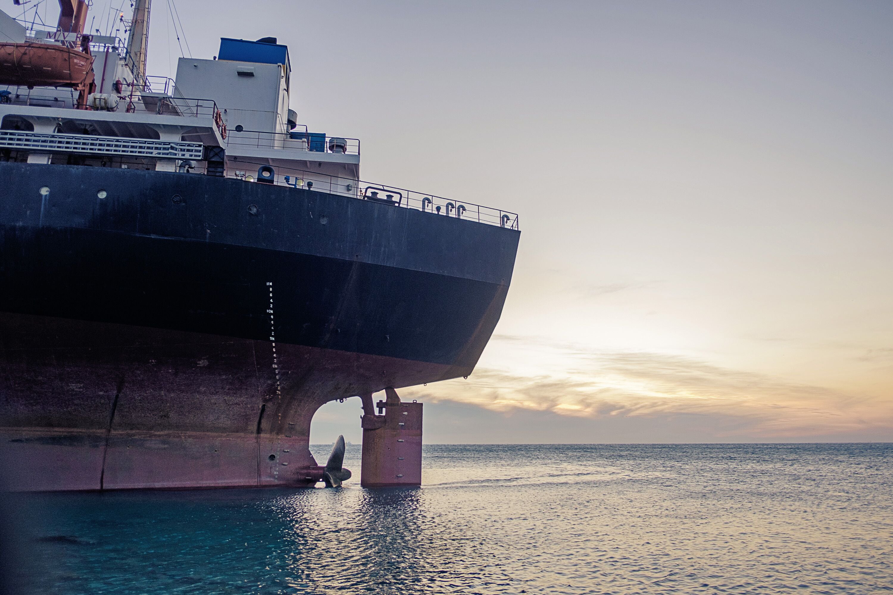 Gelendzhik, Kabardinka, Russia, 16 December 2018: Cargo ship "Rio" ran aground on coast after a storm in the black sea at sunset. View stern of the vessel.