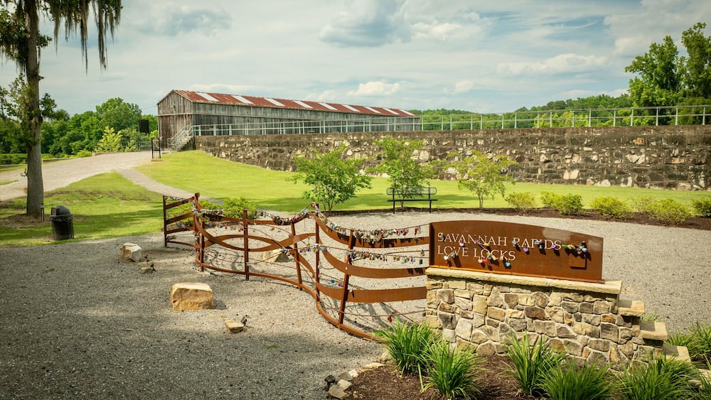 Savannah Rapids Love Locks area with a rustic building and greenery on a sunny day. Georgia, USA