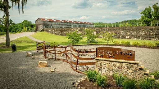Savannah Rapids Love Locks area with a rustic building and greenery on a sunny day. Georgia, USA