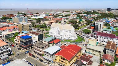 Aerial photo of Georgetown, Guyana, with colorful colonial architecture, St. George’s Cathedral, bustling streets, and a waterfront along the Demerara River