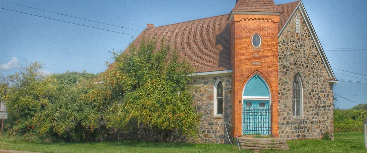 A church with a brick steeple and a blue door.