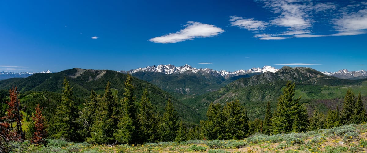 A mountain range with snow-capped peaks under a clear blue sky.