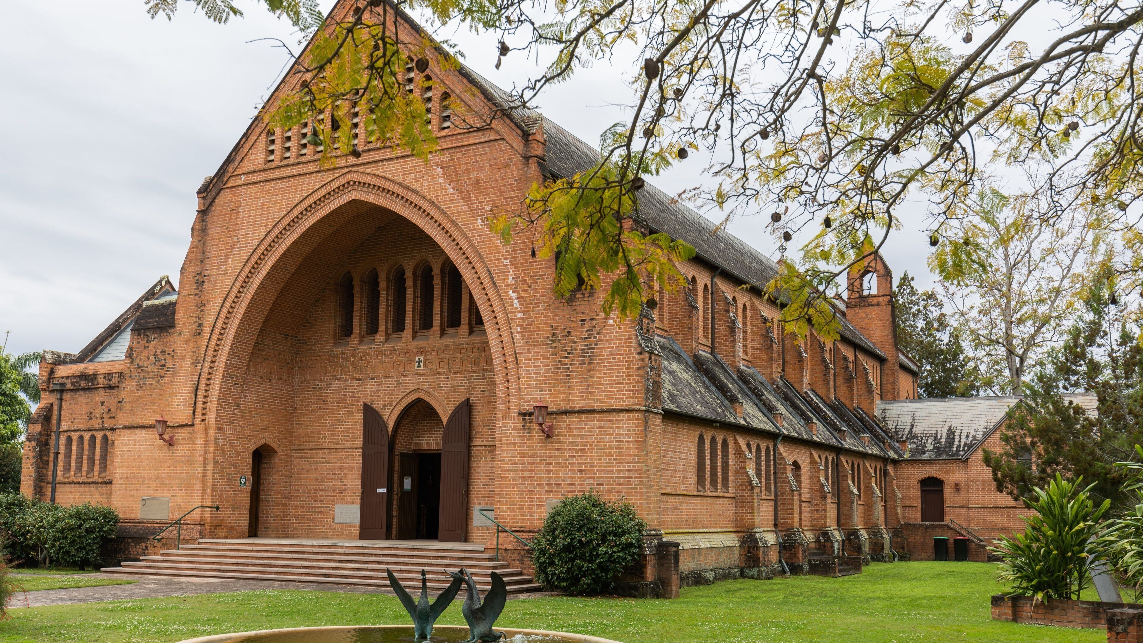 A large brick church with a prominent arched entrance and a bell tower.