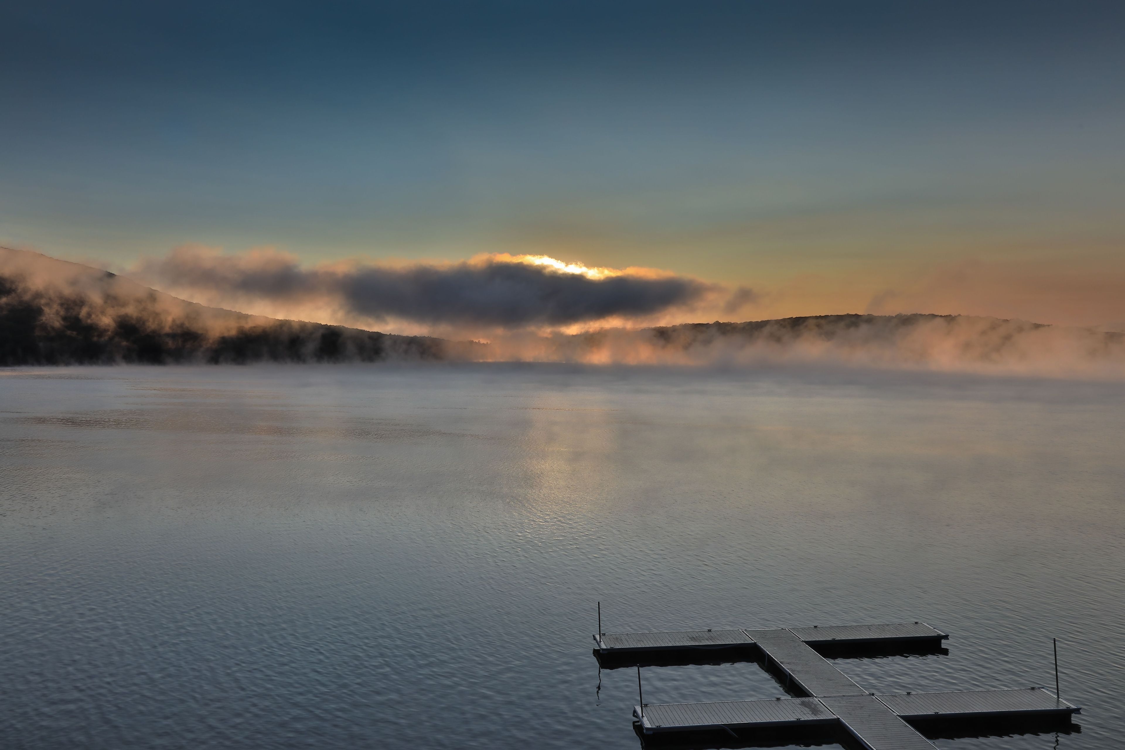 Dramatic sunrise over Deep Creek Lake with an empty dock. Maryland, USA.