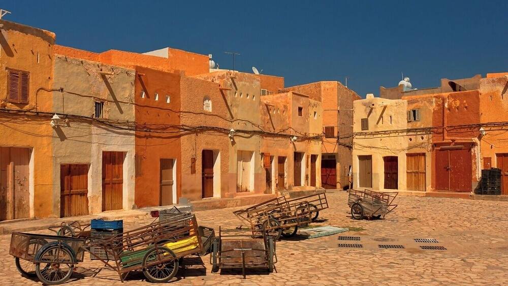 April 2011
Marché a la Criée is a market place in Beni Isguen town in M'zab valley in Algeria. Late in the afternoon it becomes the centre of the social life of Beni Isguen with the daily auction. Those who sell yell out the price of their item until someone buys it or the price is brought down.
This picture was taken during Friday prayer time, when it feels like a movie ghost town.