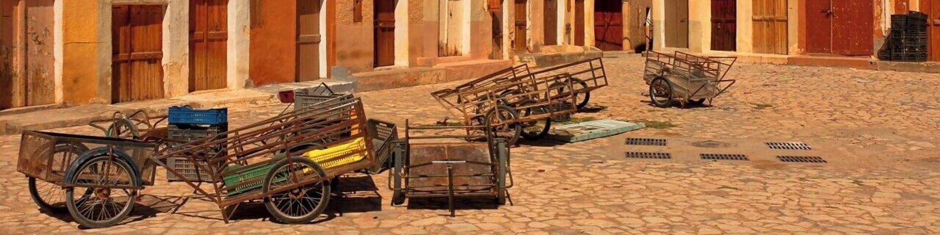 April 2011
Marché a la Criée is a market place in Beni Isguen town in M'zab valley in Algeria. Late in the afternoon it becomes the centre of the social life of Beni Isguen with the daily auction. Those who sell yell out the price of their item until someone buys it or the price is brought down.
This picture was taken during Friday prayer time, when it feels like a movie ghost town.