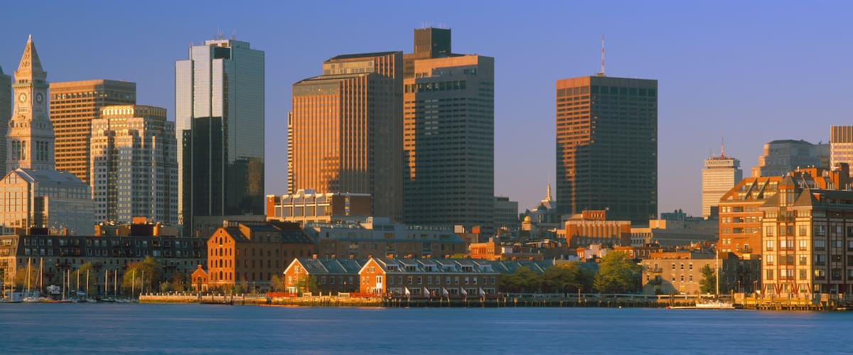 A city skyline with a mix of historic and modern buildings, a prominent clock tower, and a waterfront.