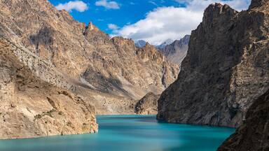 Un paisaje montañoso con un lago turquesa.
