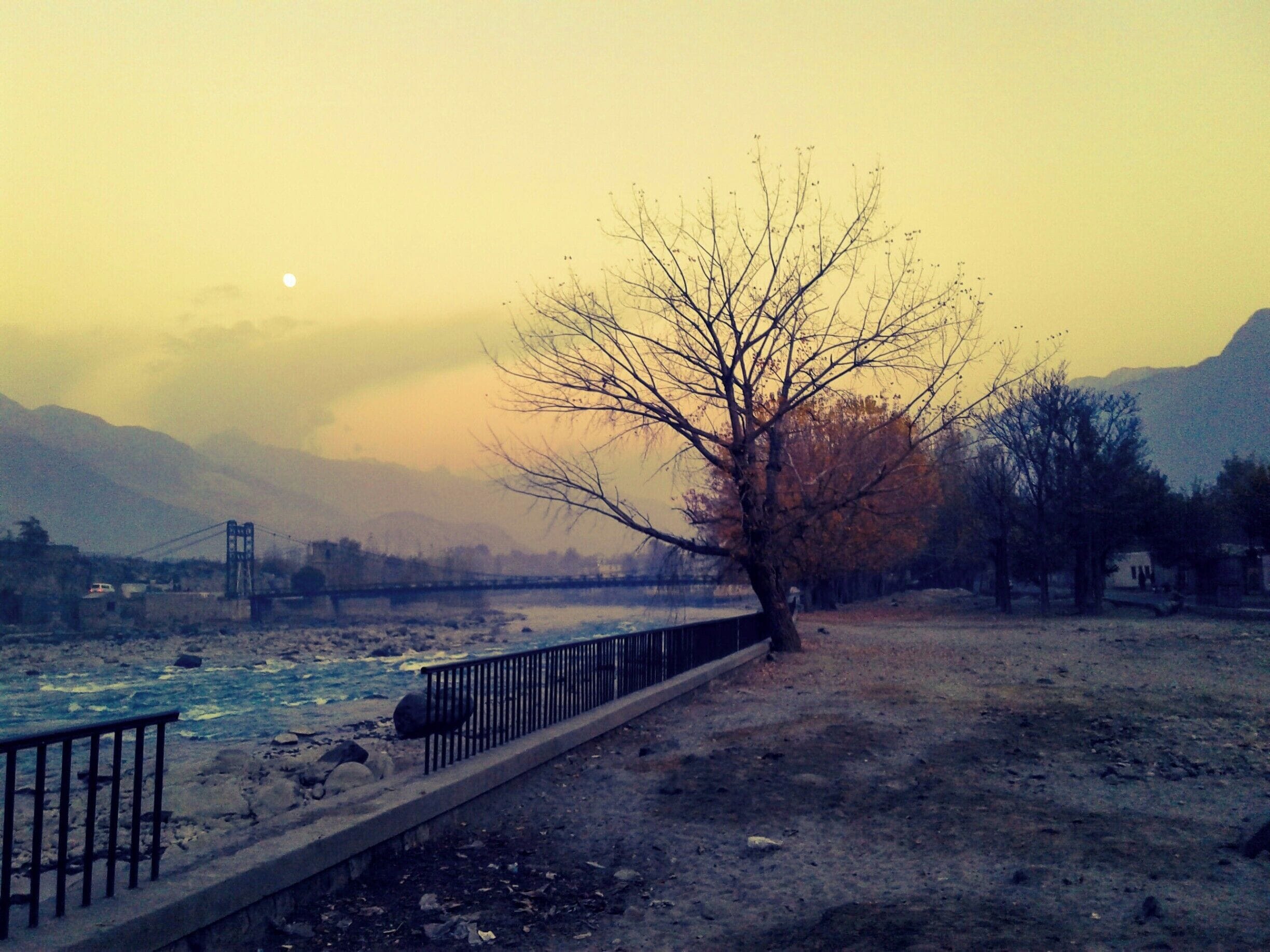 A starting winter's evening along the Gilgit River, Gilgit-Baltistan, Northern Areas of Pakistan. Moon in the background. #WinterWonders