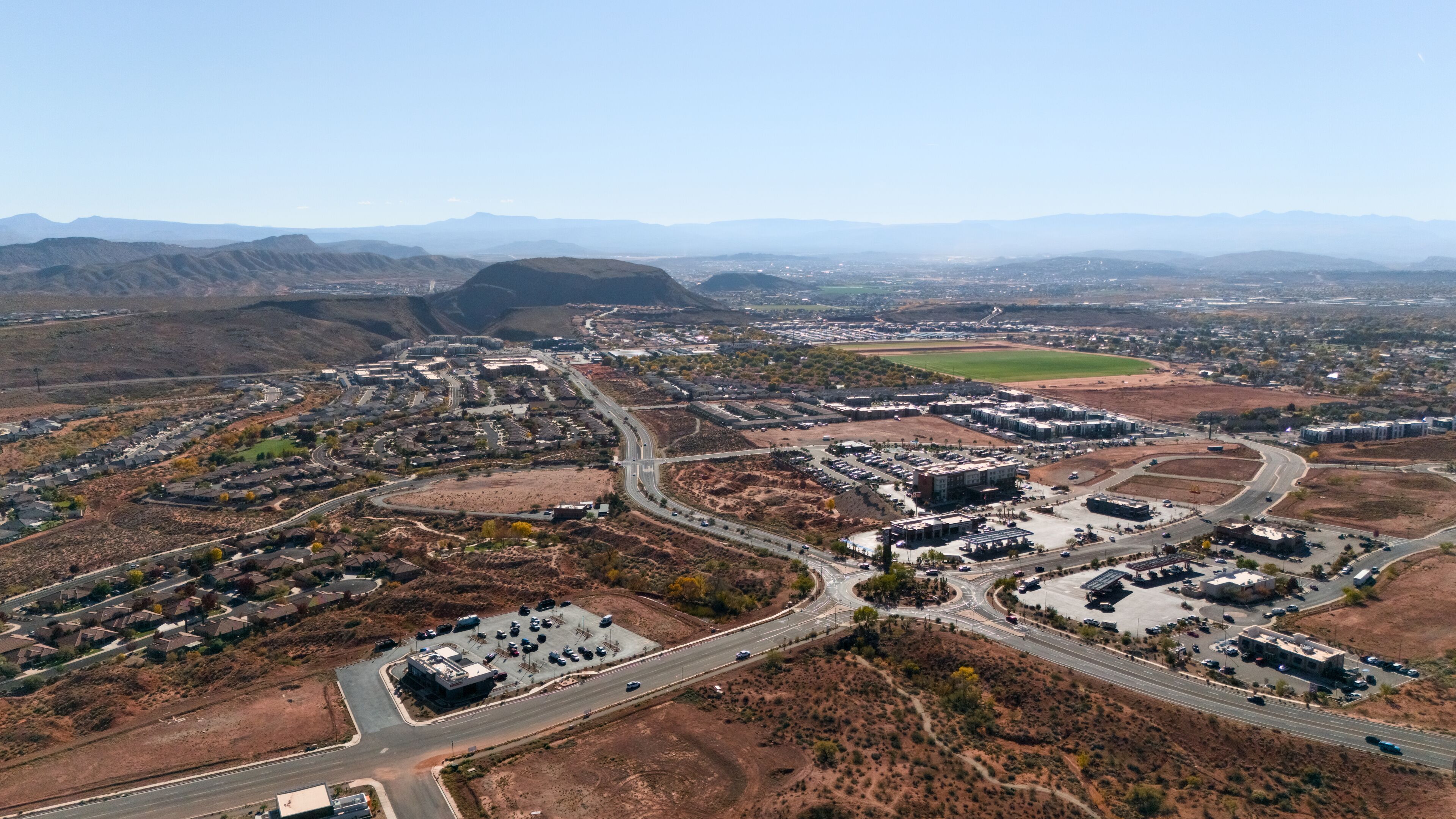 An aerial view of a suburban area with a mix of residential housing, commercial buildings, and roads.