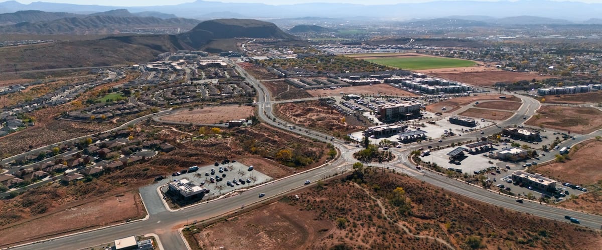 An aerial view of a suburban area with a mix of residential housing, commercial buildings, and roads.