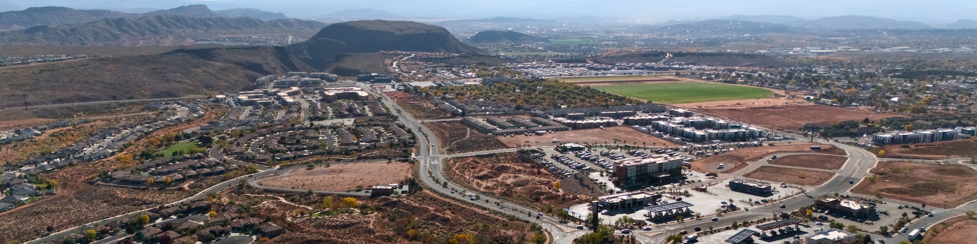 An aerial view of a suburban area with a mix of residential housing, commercial buildings, and roads.