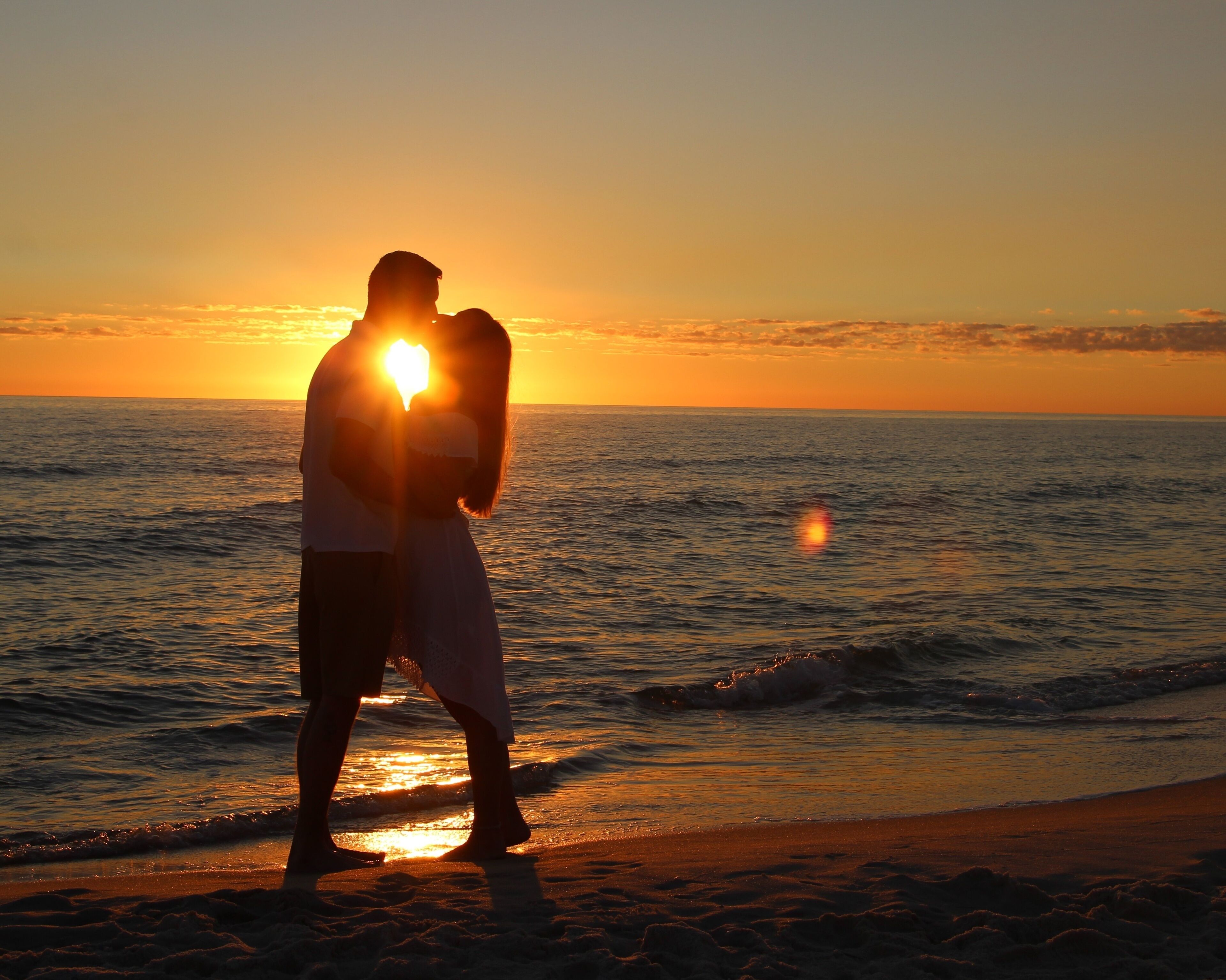 A Young Couple Silhouetted Against a Sunset on Laguna Beach in Panama City Beach, Florida