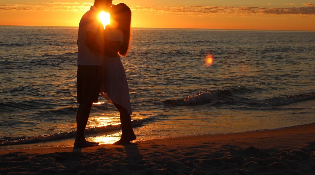 A Young Couple Silhouetted Against a Sunset on Laguna Beach in Panama City Beach, Florida