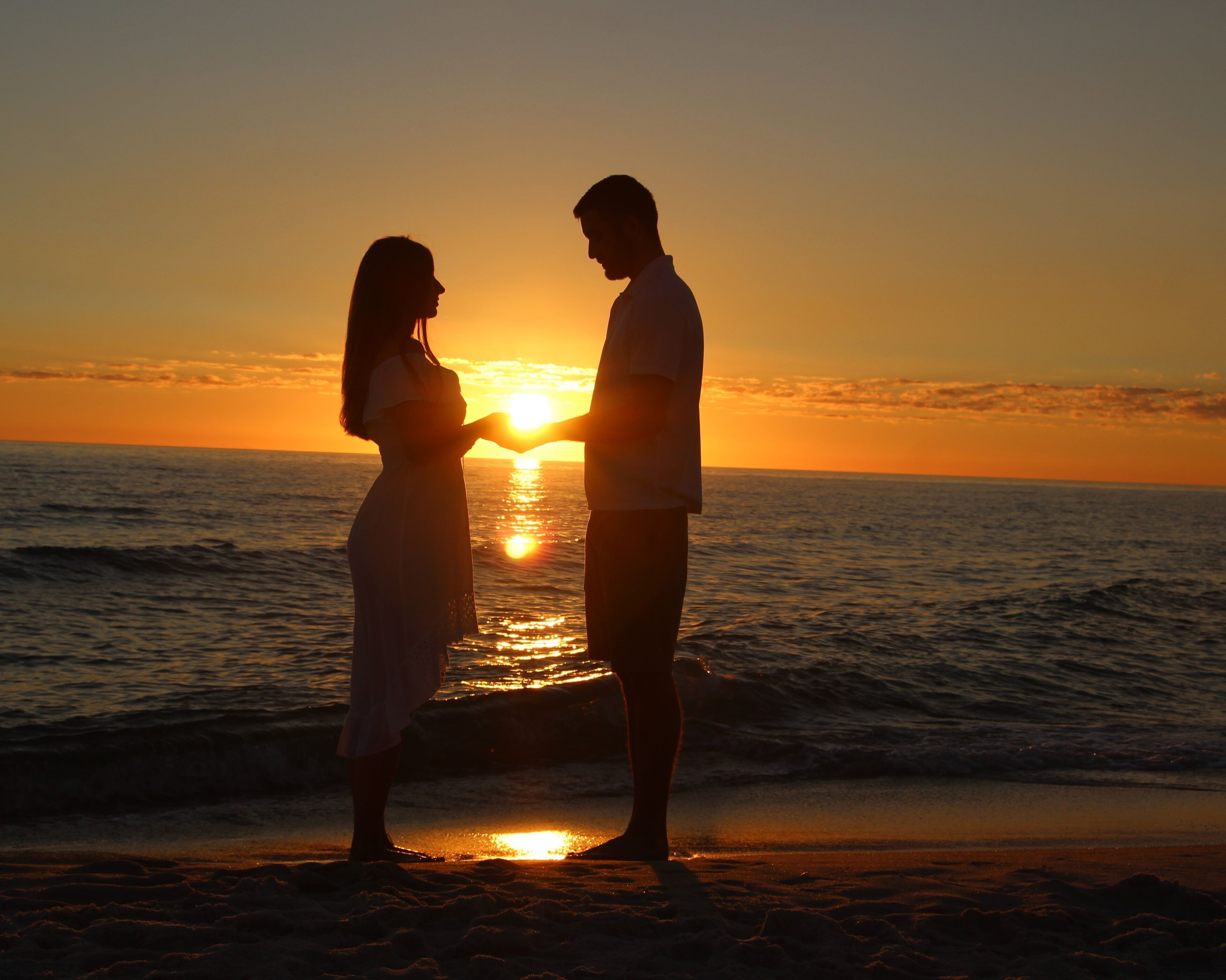 A Young Couple Silhouetted Against a Sunset on Laguna Beach in Panama City Beach, Florida