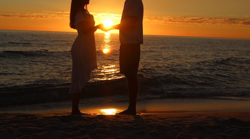 A Young Couple Silhouetted Against a Sunset on Laguna Beach in Panama City Beach, Florida