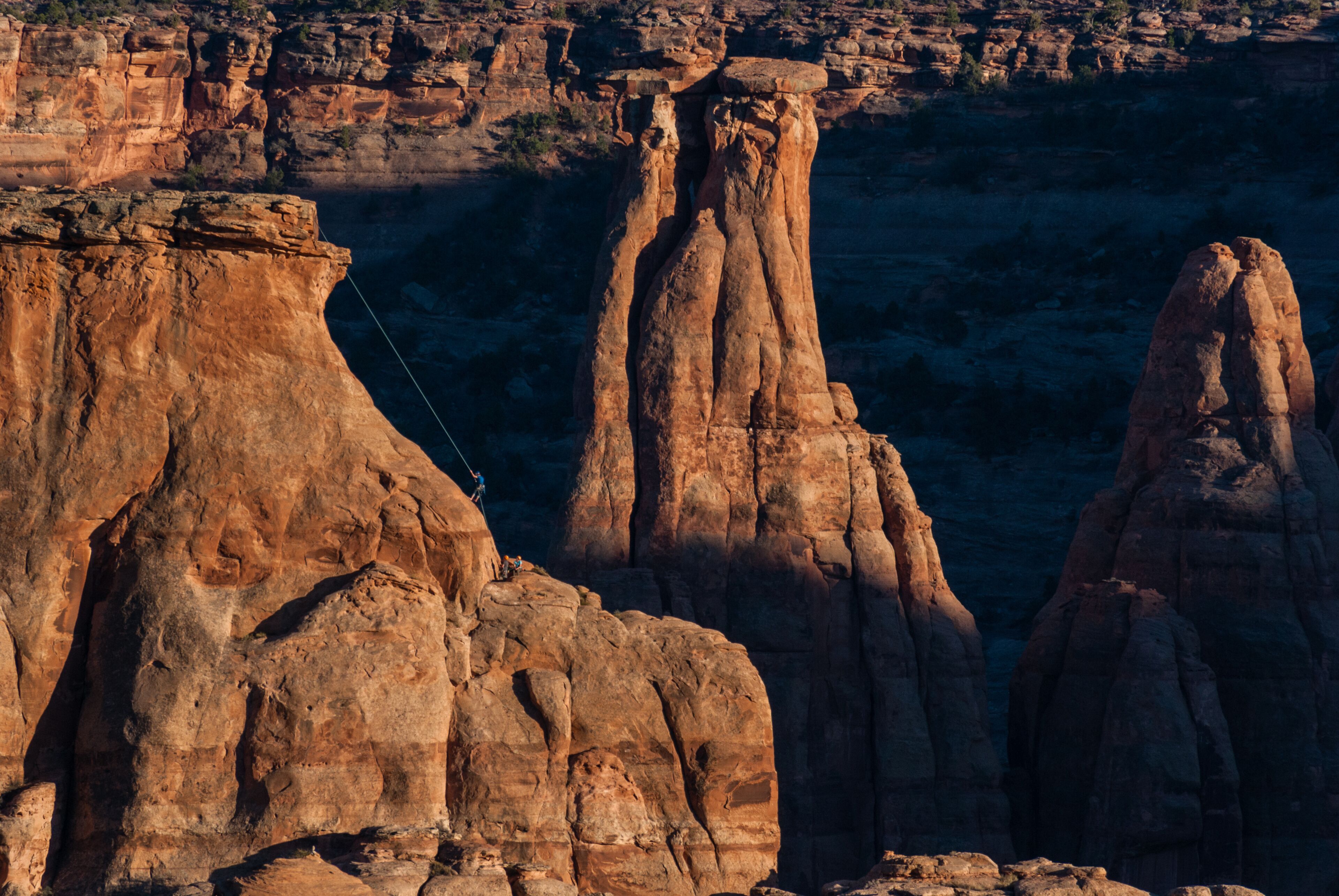 A canyon with prominent rock formations and a rope bridge.
