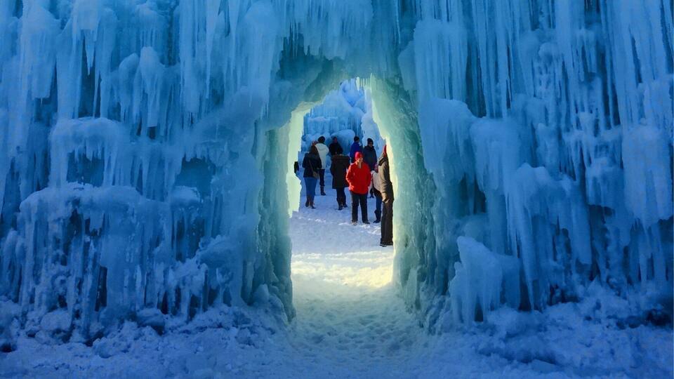 An ice archway with people walking through it.