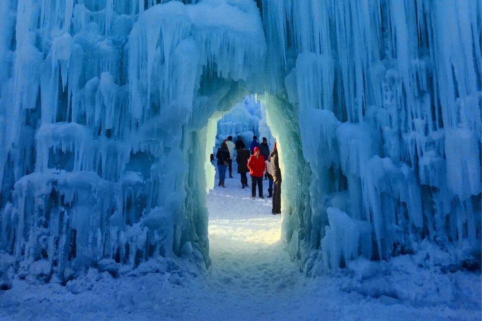 An ice archway with people walking through it.