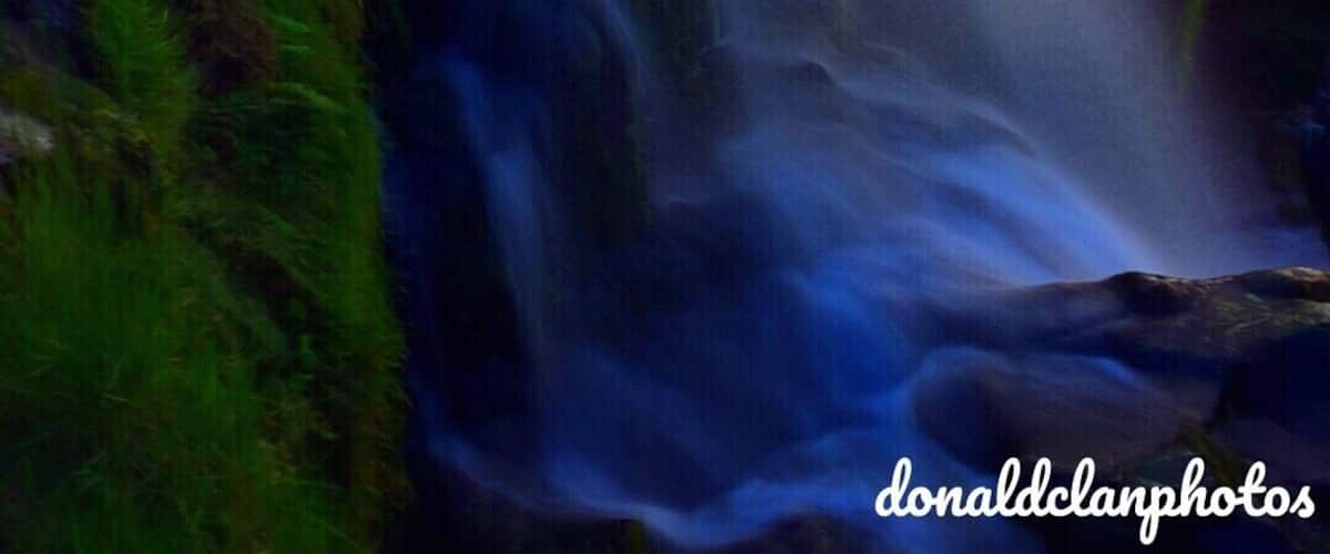 A waterfall surrounded by lush greenery.