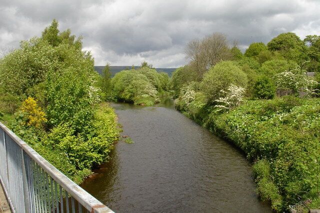 Confluence of the Glazert & Kelvin Looking east from the footbridge that replaced the original Campsie Branch railway, the water below is the River Kelvin, which makes its way to the River Clyde in the centre of Glasgow. In the distance you can see where the Glazert Water (left) joins the River Kelvin (right). With the Luggie water similarly joining the Kelvin a few hundred metres downstream this confluence was instrumental in causing flooding in to new homes that developers erected on the Kelvin flood plain. The local council then had to spend millions in building a flood prevention scheme to protect them.