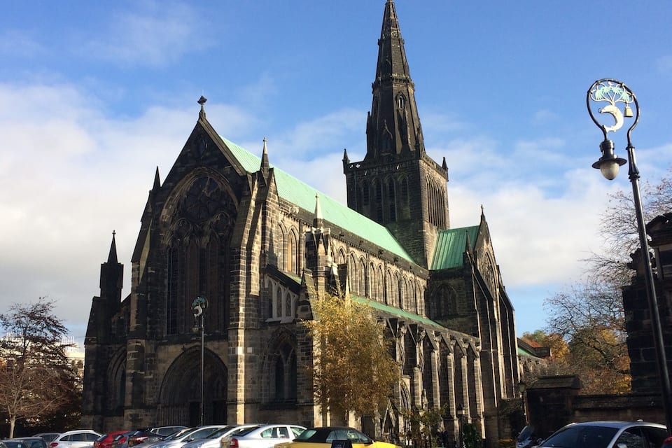 A large Gothic-style church with a tall spire and a green roof.
