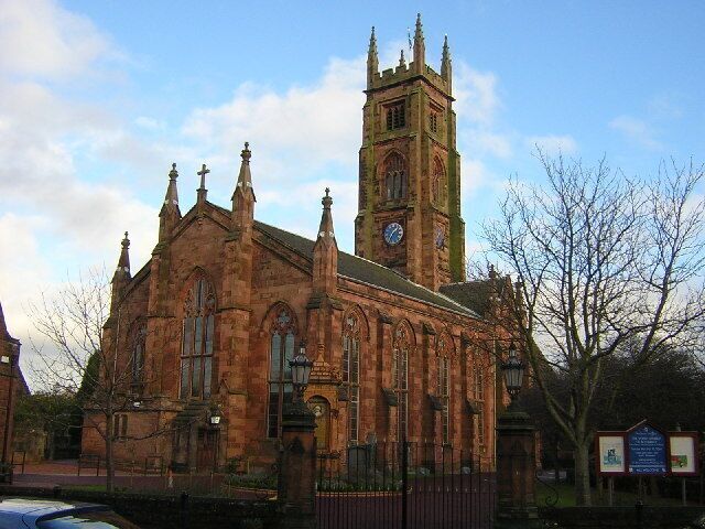 A historic church with a tall clock tower and arched windows.