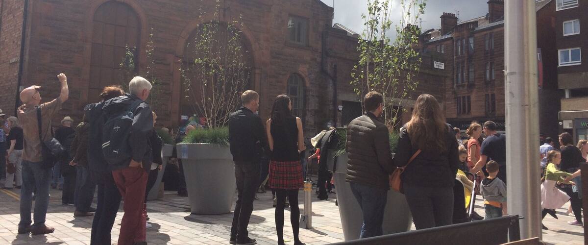 A crowded outdoor area with a historic brick building in the background.