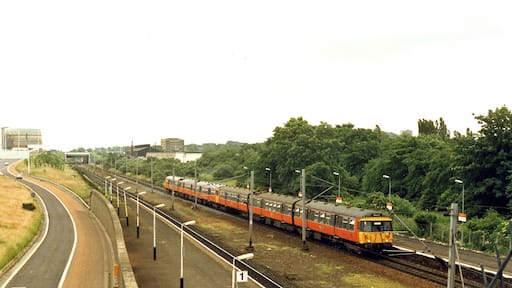 Cardonald station, 1986. View eastward beside the M8 motorway, towards Glasgow Central: ex-Caledonian & GSW Joint Glasgow Central/St Enoch - Paisley etc. main line. The Class 314 EMU train is on a Glasgow Central - Gourock (Inverclyde Line) service.