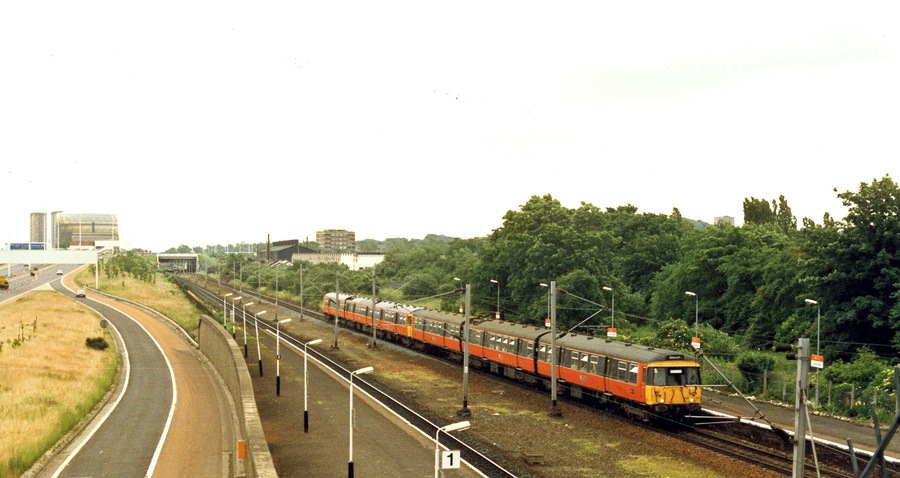 Cardonald station, 1986. View eastward beside the M8 motorway, towards Glasgow Central: ex-Caledonian & GSW Joint Glasgow Central/St Enoch - Paisley etc. main line. The Class 314 EMU train is on a Glasgow Central - Gourock (Inverclyde Line) service.