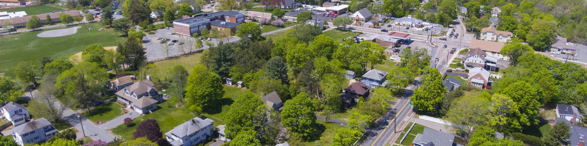An aerial view of a suburban neighborhood with houses, roads, and green spaces.