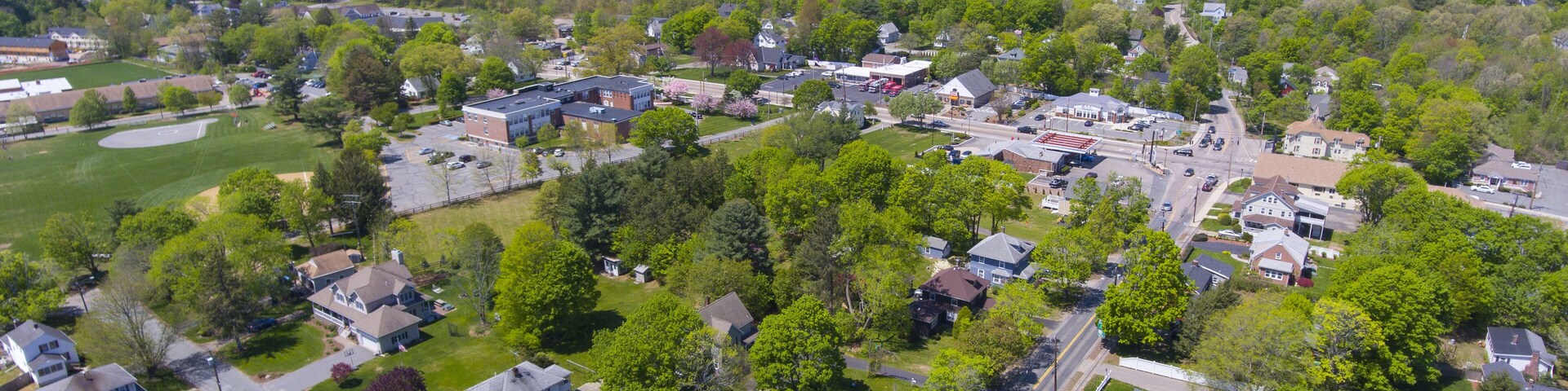Vista aérea de un barrio residencial con casas, calles y zonas verdes.