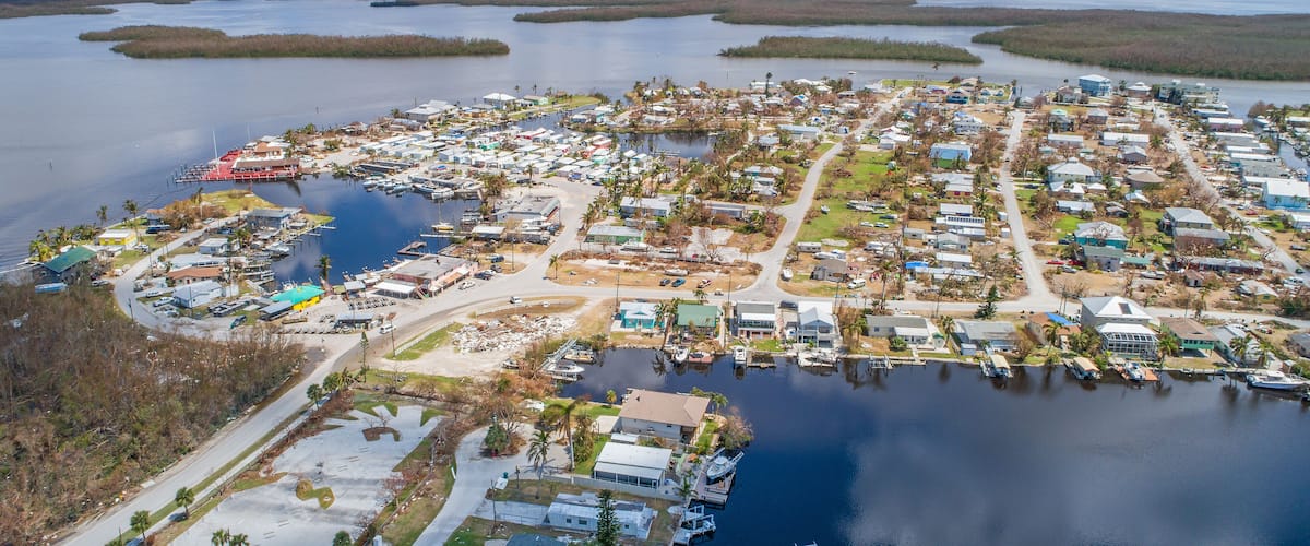 A coastal residential area with houses, docks, and a marina.