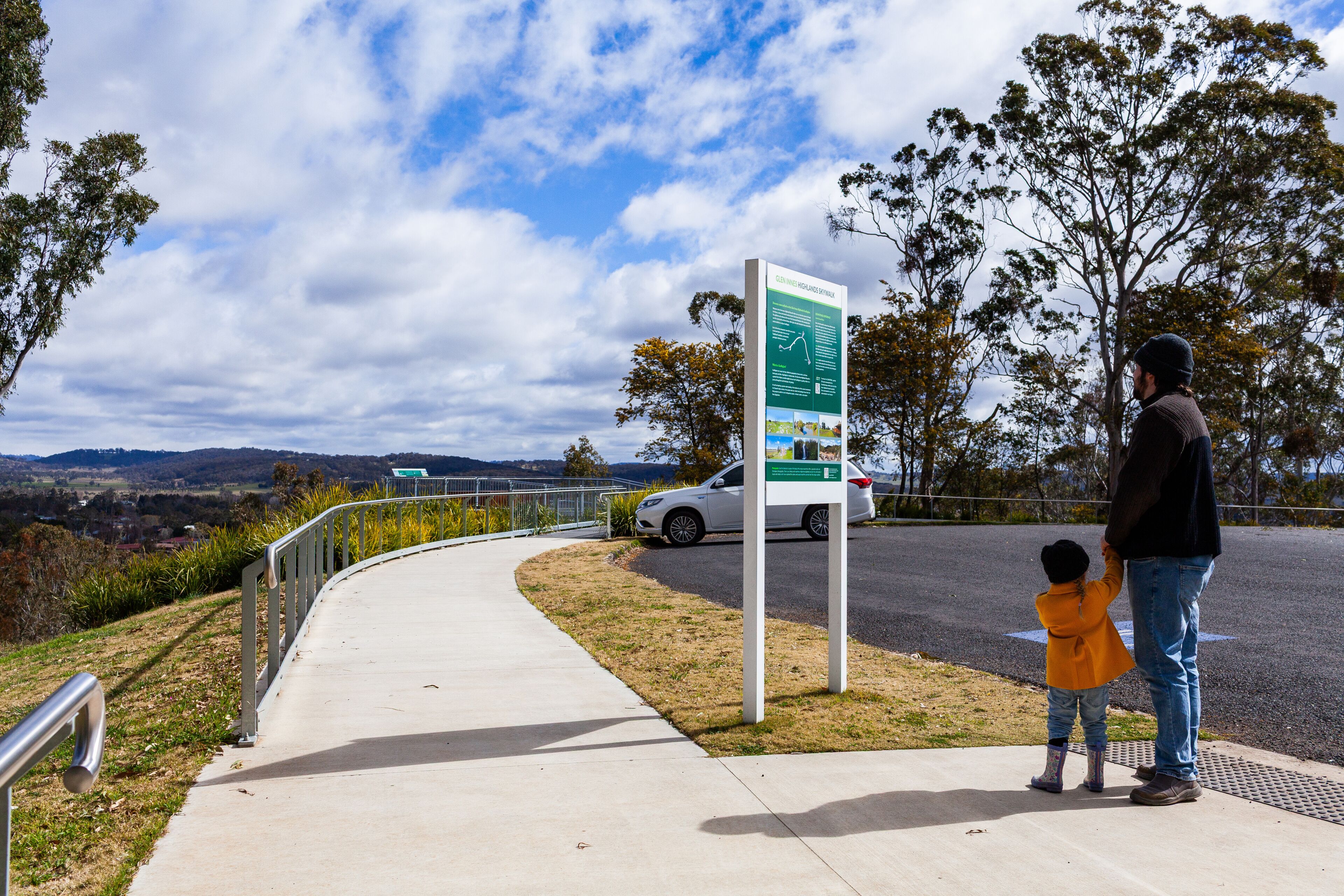 Parent and child at the Glen Innes Highlands Skywalk lookout on windy winter day